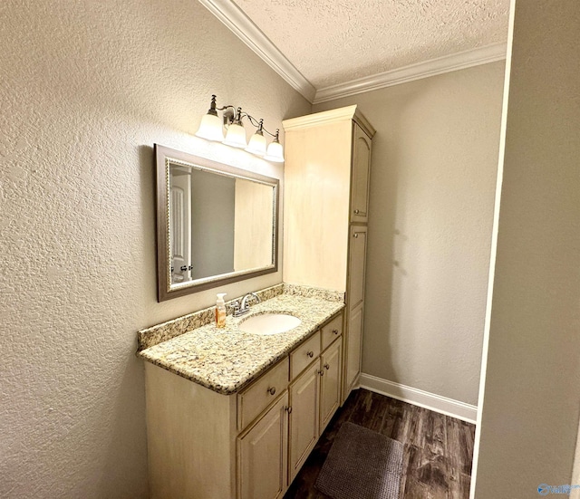 bathroom featuring crown molding, vanity, hardwood / wood-style floors, and a textured ceiling