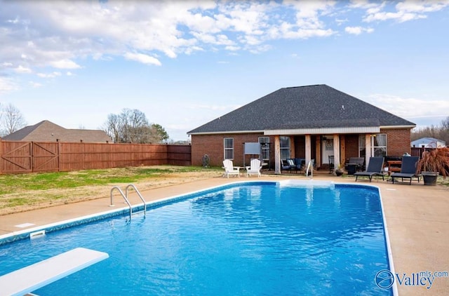 view of pool featuring a diving board and a patio area