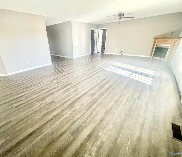 unfurnished living room featuring hardwood / wood-style flooring and ceiling fan