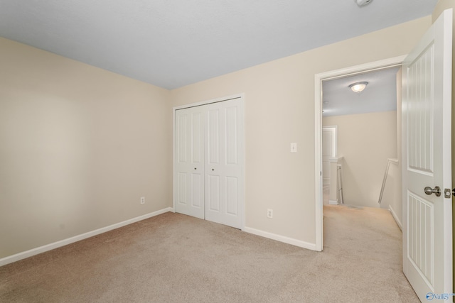 unfurnished bedroom with light carpet and a closet