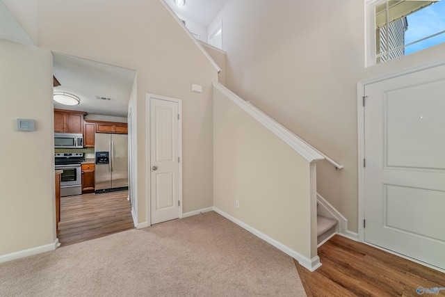 stairs featuring a high ceiling and hardwood / wood-style floors