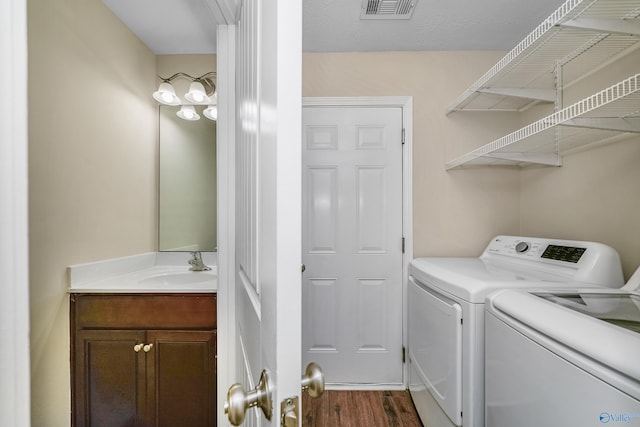 laundry room featuring sink, independent washer and dryer, and dark hardwood / wood-style floors