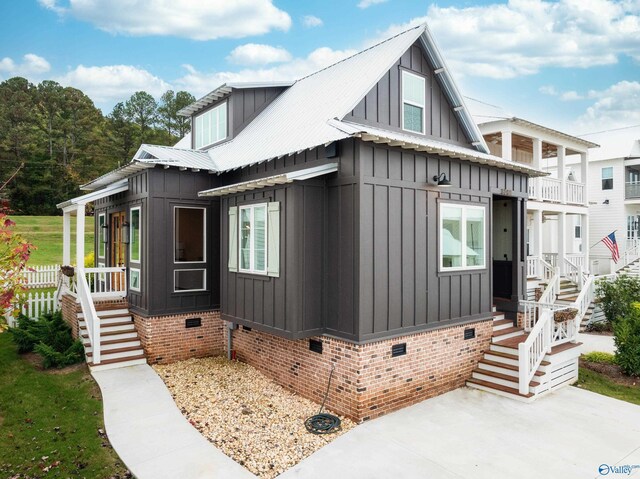 view of home's exterior with crawl space, board and batten siding, and metal roof