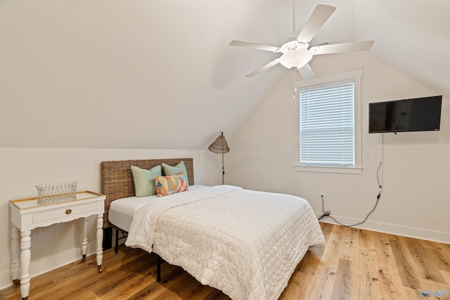bedroom featuring baseboards, light wood-style flooring, and vaulted ceiling