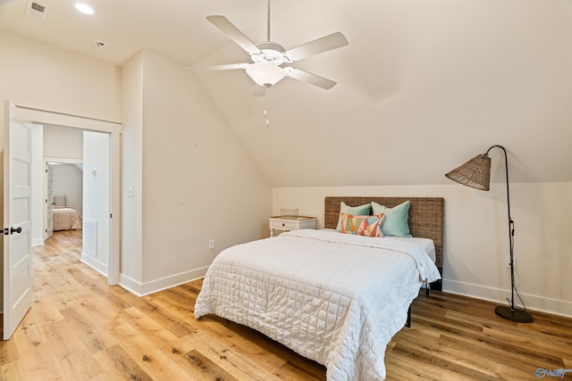 bedroom featuring visible vents, lofted ceiling, light wood-style floors, and baseboards