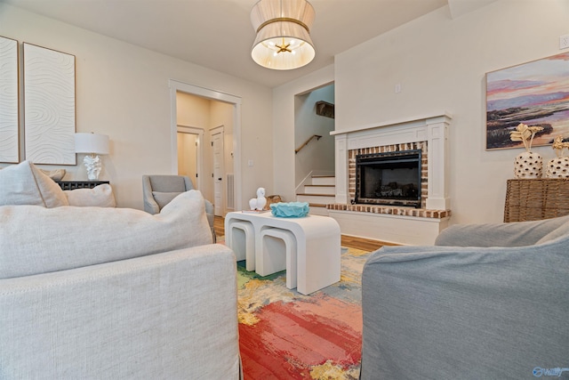 living room featuring stairway, a fireplace, and wood finished floors