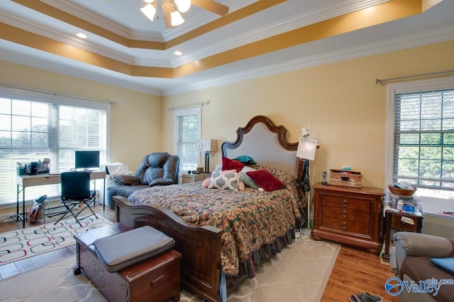 bedroom with ceiling fan, ornamental molding, multiple windows, and light wood-type flooring