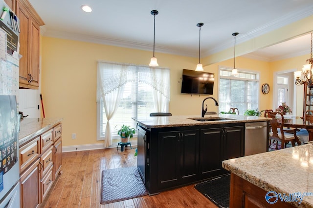 kitchen featuring light stone countertops, light hardwood / wood-style floors, stainless steel dishwasher, ornamental molding, and a kitchen island with sink