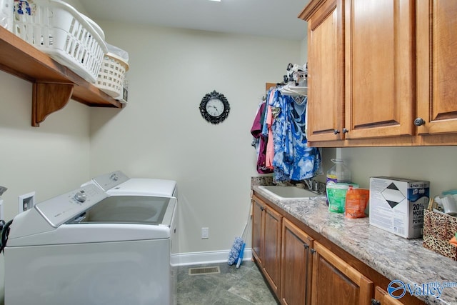 laundry area with sink, independent washer and dryer, and cabinets