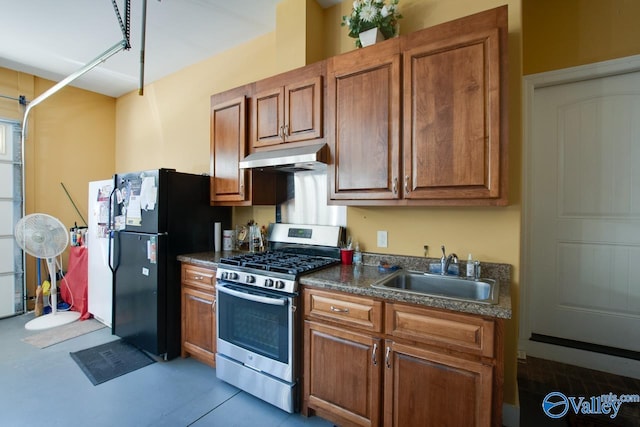 kitchen featuring sink, black refrigerator, and stainless steel gas range oven