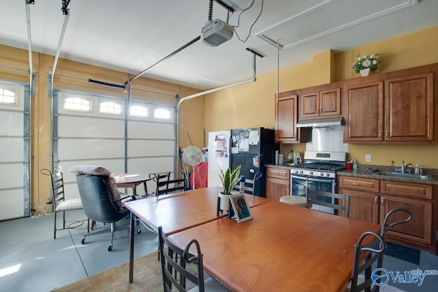 garage featuring sink, a garage door opener, and black fridge