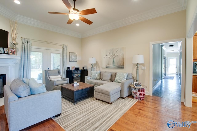 living room with ornamental molding, light hardwood / wood-style flooring, and ceiling fan