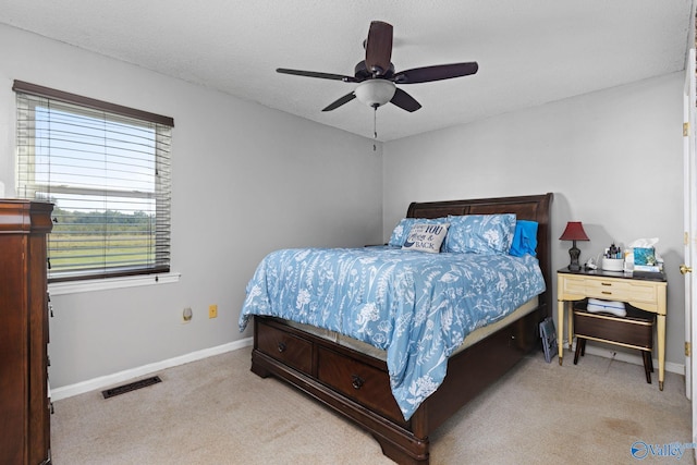 carpeted bedroom with ceiling fan and a textured ceiling