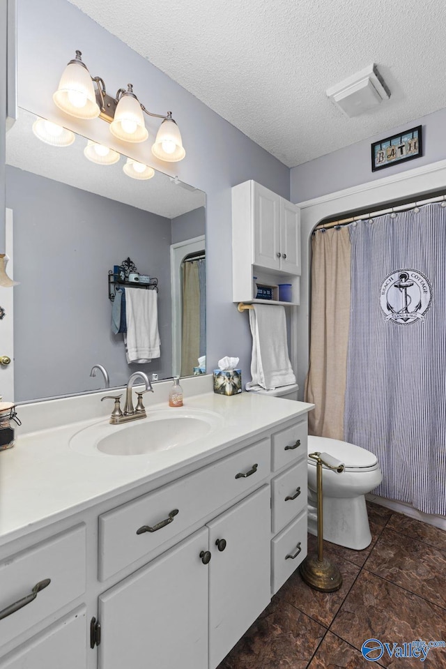 bathroom with vanity, toilet, a textured ceiling, and tile patterned floors