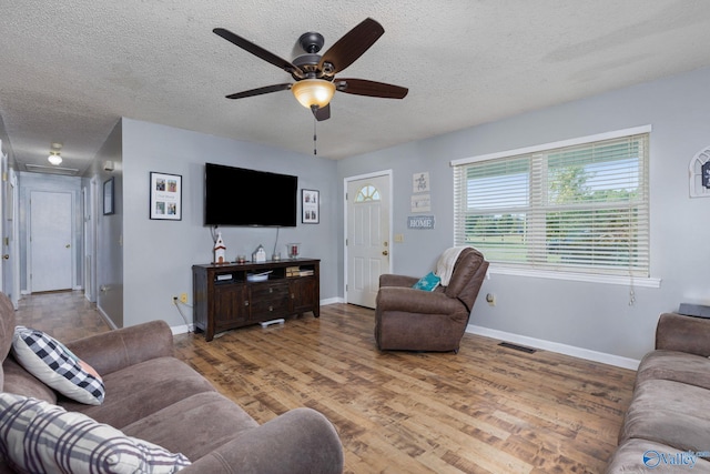 living room with ceiling fan, wood-type flooring, and a textured ceiling