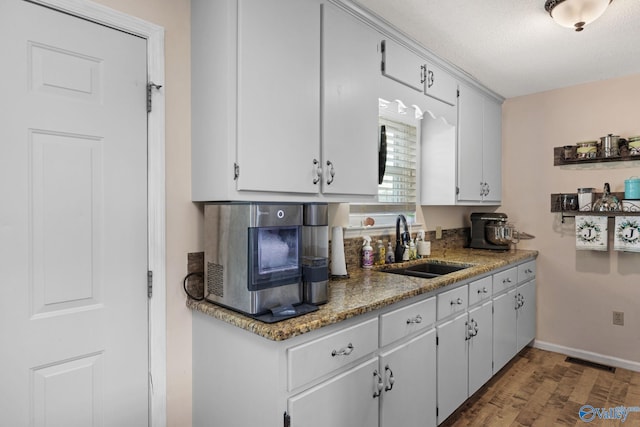 kitchen featuring a textured ceiling, white cabinets, sink, and dark hardwood / wood-style flooring