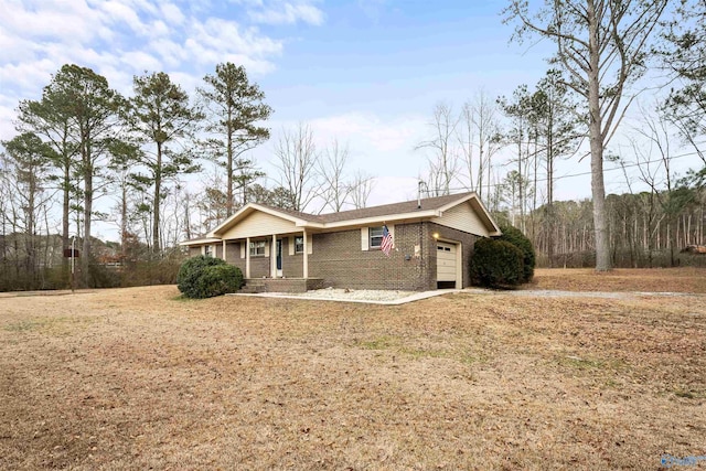 ranch-style house featuring a garage, a porch, and a front lawn