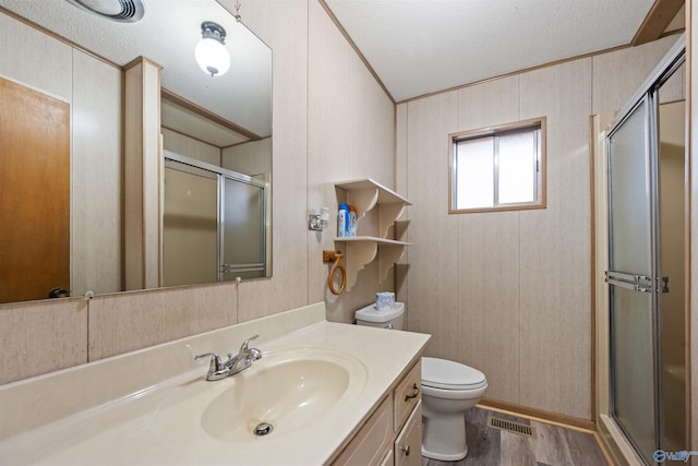 bathroom featuring walk in shower, toilet, wood-type flooring, a textured ceiling, and vanity