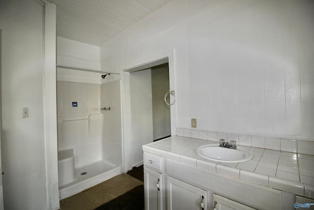 bathroom with walk in shower and vanity