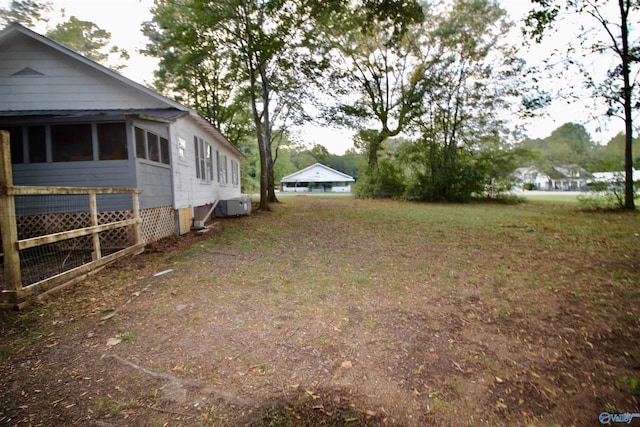 view of yard featuring central AC unit and a sunroom