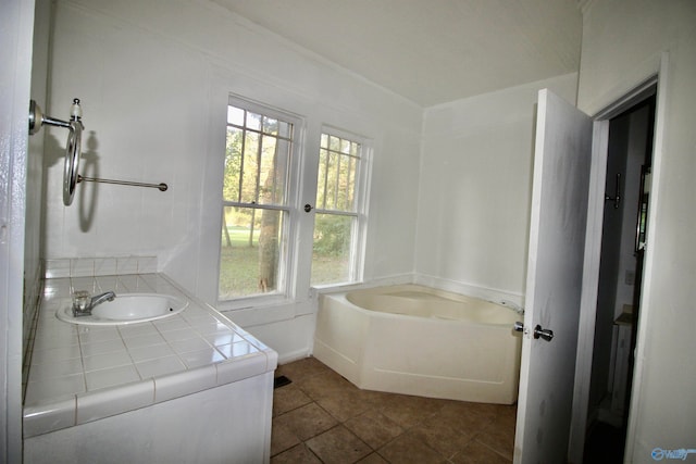 bathroom featuring a bathtub, sink, and tile patterned floors