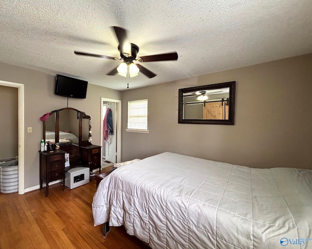 1300 7th Ave, Athens, AL 35611 - bedroom with wood finished floors, a textured ceiling, a ceiling fan, baseboards, and a closet