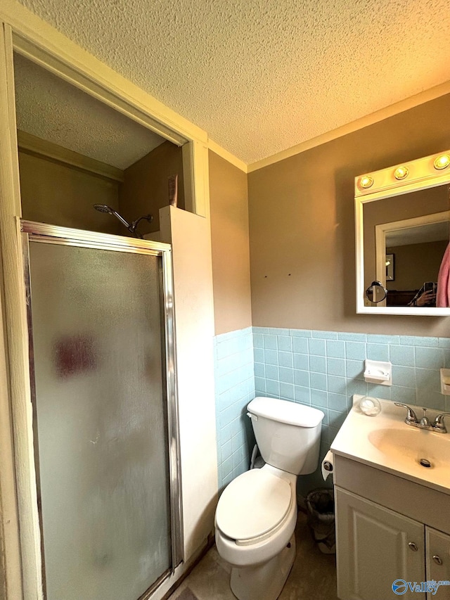 1300 7th Ave, Athens, AL 35611 - full bathroom featuring a textured ceiling, a stall shower, vanity, a wainscoted wall, and toilet