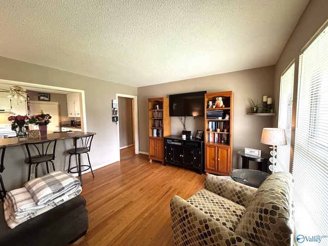 1300 7th Ave, Athens, AL 35611 - living room with light wood-style floors, a textured ceiling, and baseboards