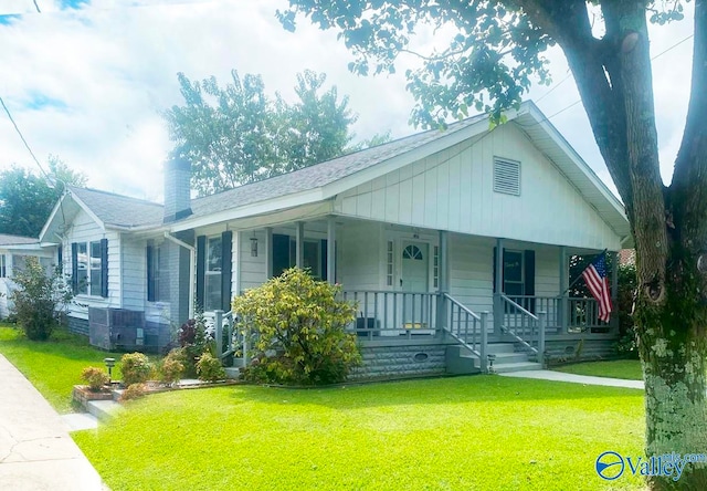 view of front of home with a porch, central AC, and a front lawn