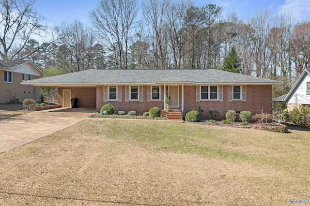 single story home featuring brick siding, an attached carport, driveway, and a front yard