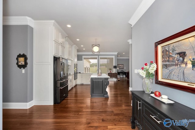 kitchen with white cabinets, dark hardwood / wood-style floors, crown molding, and a kitchen island