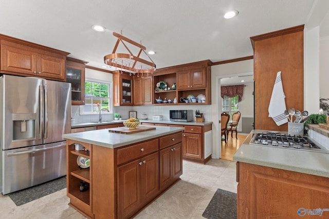 kitchen featuring stainless steel appliances, open shelves, ornamental molding, and brown cabinets