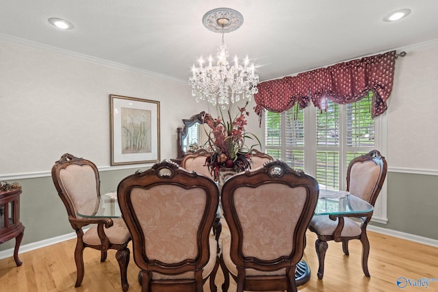 dining space with crown molding, a notable chandelier, wood finished floors, and baseboards