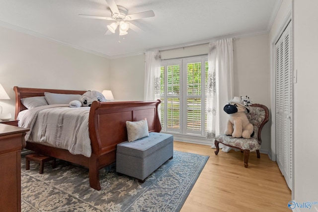 bedroom featuring ornamental molding, a ceiling fan, baseboards, and light wood-style floors
