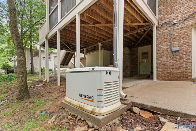 exterior details with stairs, a power unit, and brick siding