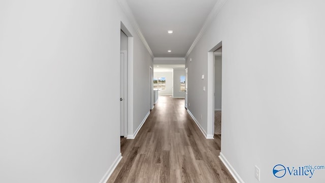 hallway with crown molding and light hardwood / wood-style flooring