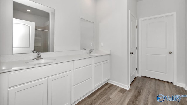 bathroom featuring hardwood / wood-style flooring, vanity, and a shower with door