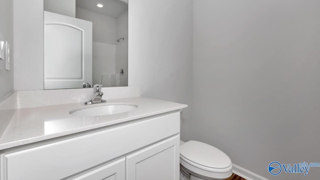 bathroom featuring vanity, a shower, and toilet