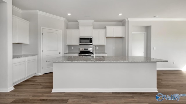 kitchen with sink, stainless steel appliances, white cabinets, and a center island with sink