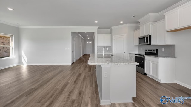 kitchen with sink, an island with sink, white cabinets, and appliances with stainless steel finishes