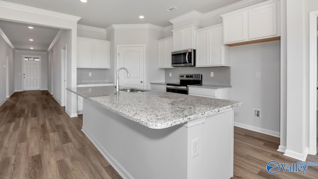 kitchen with sink, stainless steel appliances, white cabinets, and a center island with sink