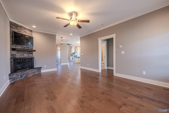 unfurnished living room with ornamental molding, a stone fireplace, wood-type flooring, and ceiling fan