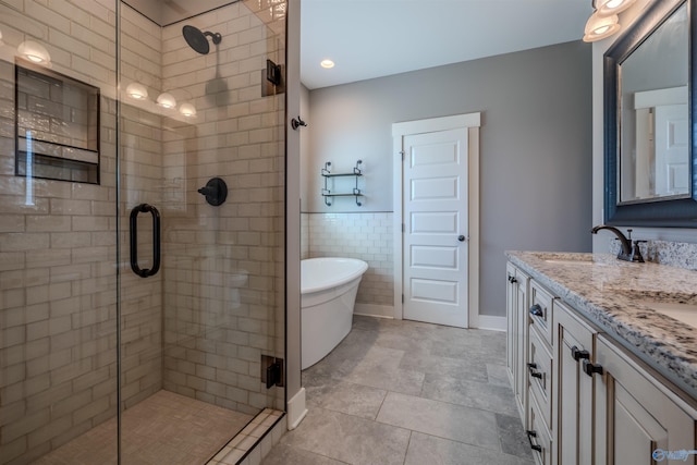 bathroom featuring vanity, tile walls, and separate shower and tub