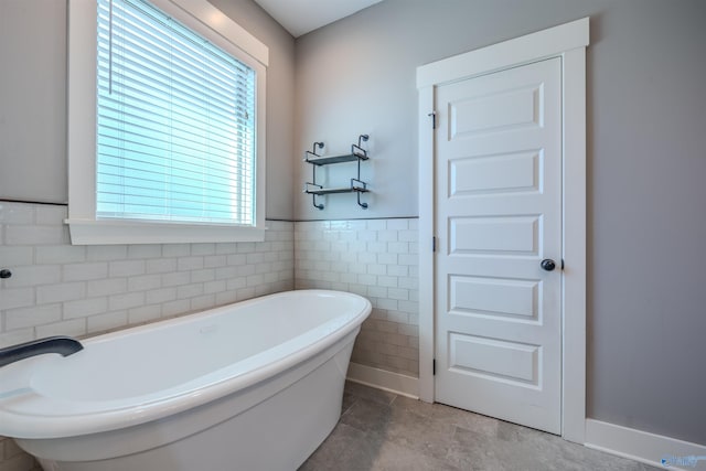 bathroom featuring tile walls and a bathing tub