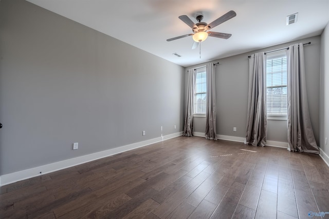 empty room with ceiling fan and dark hardwood / wood-style flooring