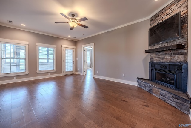 unfurnished living room with dark wood-type flooring, crown molding, a fireplace, and ceiling fan