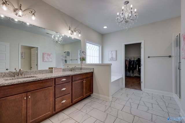 bathroom with a tub to relax in, vanity, and a chandelier