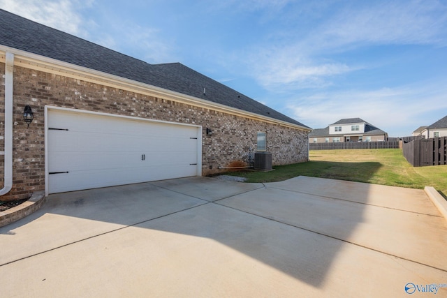 view of side of property with a yard and central air condition unit