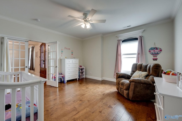 bedroom featuring a nursery area, wood-type flooring, ceiling fan, crown molding, and french doors