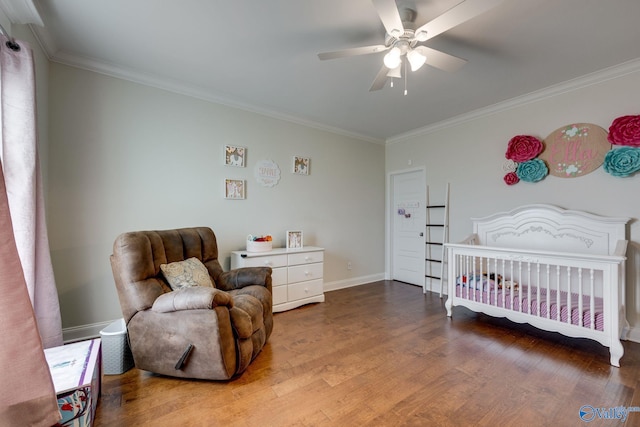 bedroom featuring hardwood / wood-style flooring, crown molding, a nursery area, and ceiling fan